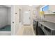 Bright laundry room with modern washer and dryer, and a walk-in shower with eye-catching green tile at 2250 64Th N St, St Petersburg, FL 33710