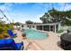 Aerial view of backyard pool with blue chairs, turf area, and screened patio at 2250 64Th N St, St Petersburg, FL 33710