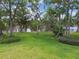 Inviting backyard featuring a lush lawn, mature trees, and a serene pond view at 2537 Oakleaf Ln # 32A, Clearwater, FL 33763