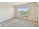 Bright bedroom with neutral walls, plush carpeting, and a large window offering scenic views at 2547 Lexington Oak Dr, Brandon, FL 33511