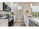 Bright kitchen showcasing stainless steel appliances, white cabinets, and ample counter space for cooking at 2547 Lexington Oak Dr, Brandon, FL 33511