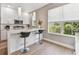 Bright kitchen featuring white cabinetry, stainless steel appliances, and barstool seating by a window at 2547 Lexington Oak Dr, Brandon, FL 33511