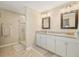 Bright bathroom with double vanity, granite countertops, and glass-enclosed shower at 2882 Autumn Rock Dr, Zephyrhills, FL 33540