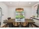 The dining room has a decorative light fixture, and a view through the window to the front yard at 3008 S Church Ave, Tampa, FL 33629