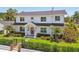 Charming two-story home with lush landscaping, a fenced yard, and a striking red door at 3008 S Church Ave, Tampa, FL 33629