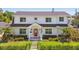 Charming two-story home with landscaped yard, bright red door, and manicured shrubs at 3008 S Church Ave, Tampa, FL 33629