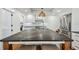 A kitchen island with a black marble countertop, modern light fixtures, and stainless steel appliances at 3008 S Church Ave, Tampa, FL 33629