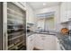 Kitchenette with white cabinets, stone countertops, stainless steel appliances, and a wine fridge at 3008 S Church Ave, Tampa, FL 33629