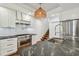 This kitchen has stainless steel appliances, a stone countertop, and a woven light fixture at 3008 S Church Ave, Tampa, FL 33629
