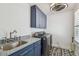 Laundry room featuring blue cabinets, granite countertops, and stainless steel washer and dryer at 3008 S Church Ave, Tampa, FL 33629