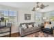 Brightly lit living area featuring a comfortable couch, windows with blinds and unique ceiling fan at 3008 S Church Ave, Tampa, FL 33629