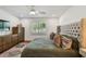 Bedroom with hardwood floors, a ceiling fan, and a large bed with a tufted headboard at 3008 S Church Ave, Tampa, FL 33629