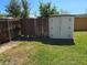 A backyard featuring a storage shed and a dilapidated wooden fence at 315 Shore E Dr, Oldsmar, FL 34677