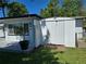 This backyard shows a matching shed near the gray wooden deck at 315 Shore E Dr, Oldsmar, FL 34677