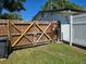 An old wooden gate with a yellow brace is found in the backyard at 315 Shore E Dr, Oldsmar, FL 34677