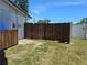 A dilapidated fence in a backyard of grass, next to a white fence at 315 Shore E Dr, Oldsmar, FL 34677