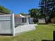 A backyard with a gray wooden deck, a white fence, and a shed at 315 Shore E Dr, Oldsmar, FL 34677