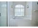 Bright bathroom showcases a tiled tub with a window, as well as a glass-doored shower to the side at 316 Crystal Goblet Ct, Valrico, FL 33594