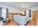 This bedroom features wood laminate flooring, a ceiling fan, and built-in headboard with mirrored accents at 316 Crystal Goblet Ct, Valrico, FL 33594