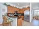 Kitchen with stainless steel appliances, dark granite countertops, wood cabinetry, breakfast bar and tile floors at 316 Crystal Goblet Ct, Valrico, FL 33594