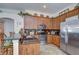 Kitchen with stainless steel appliances, dark granite countertops, wood cabinetry, breakfast bar and tile floors at 316 Crystal Goblet Ct, Valrico, FL 33594