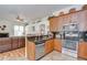 This open kitchen showcases dark granite counters, wood cabinetry, and stainless steel appliances at 316 Crystal Goblet Ct, Valrico, FL 33594