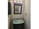 Stylish half bathroom features a black vanity and modern lighting at 3206 W Azeele St # 108, Tampa, FL 33609