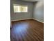 A cozy bedroom features a window letting in natural light and beautiful wood-look floors at 3206 W Azeele St # 108, Tampa, FL 33609