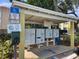Community mailboxes under a covered structure with signage and waste disposal for resident convenience at 3206 W Azeele St # 108, Tampa, FL 33609