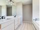 Well-lit bathroom with double vanity, modern fixtures, and a tile floor adjacent to a tub at 3434 E Keysville Rd, Lithia, FL 33547
