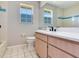Bright bathroom featuring a vanity with modern fixtures, tile floor, and two large windows for natural light at 3434 E Keysville Rd, Lithia, FL 33547