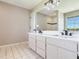 Bright bathroom with double vanity, modern fixtures, and tile floor near a separate shower at 3434 E Keysville Rd, Lithia, FL 33547
