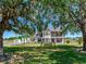 Landscaped front yard featuring mature shade trees and a home with a balcony and bay windows at 3434 E Keysville Rd, Lithia, FL 33547