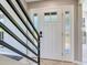 Welcoming front entrance featuring a white door with sidelights and a modern black railing at 3434 E Keysville Rd, Lithia, FL 33547
