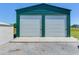 This large, green steel garage features two white roll up doors at 3434 E Keysville Rd, Lithia, FL 33547