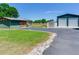 View of outbuildings, including a shed, barn, and an additional green steel garage at 3434 E Keysville Rd, Lithia, FL 33547