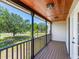 Inviting covered porch with wooden ceiling and railing overlooking the serene neighborhood at 3434 E Keysville Rd, Lithia, FL 33547
