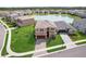 Aerial view showcasing a beautiful two-story home with a well-manicured lawn, a pond, and a paver driveway at 3488 Great Banyan Way, Wesley Chapel, FL 33543