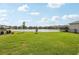 Lush green lawn extends to a pond, enhancing the peaceful backyard at 3488 Great Banyan Way, Wesley Chapel, FL 33543