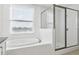 Modern bathroom showcasing a soaking tub and glass-enclosed shower at 3488 Great Banyan Way, Wesley Chapel, FL 33543