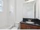 Bright bathroom featuring a granite countertop, white tiles, and modern fixtures at 3488 Great Banyan Way, Wesley Chapel, FL 33543