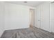 Neutral bedroom featuring grey carpet, white walls and trim, and ample closet space at 3488 Great Banyan Way, Wesley Chapel, FL 33543