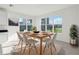 Bright dining area with large windows, modern furnishings, and views of the lake at 3488 Great Banyan Way, Wesley Chapel, FL 33543
