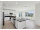Well-lit kitchen with a large island, stainless steel appliances, and views of the backyard at 3488 Great Banyan Way, Wesley Chapel, FL 33543