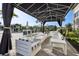 Elegant outdoor lounge area with comfortable seating under a stylish canopy and well manicured garden at 3488 Great Banyan Way, Wesley Chapel, FL 33543