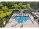 Aerial view of the pool, featuring playful water features, shaded seating, and tropical surroundings at 3488 Great Banyan Way, Wesley Chapel, FL 33543
