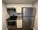 Kitchen with stainless steel appliances including a microwave, range, and refrigerator, maximizing space and functionality at 3802 N Oak Dr # W22, Tampa, FL 33611