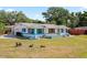 Beautiful single-story home featuring turquoise accents, a well-maintained lawn, and mature trees at 4421 28Th N Ave, St Petersburg, FL 33713