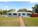 Charming single-story home featuring a brick walkway, turquoise accents, and a well-manicured lawn at 4421 28Th N Ave, St Petersburg, FL 33713