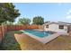A clear backyard pool surrounded by a concrete patio and wooden fence creates a private, relaxing oasis at 4421 28Th N Ave, St Petersburg, FL 33713
